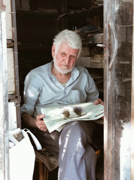 a man sitting on a chair holding a paper