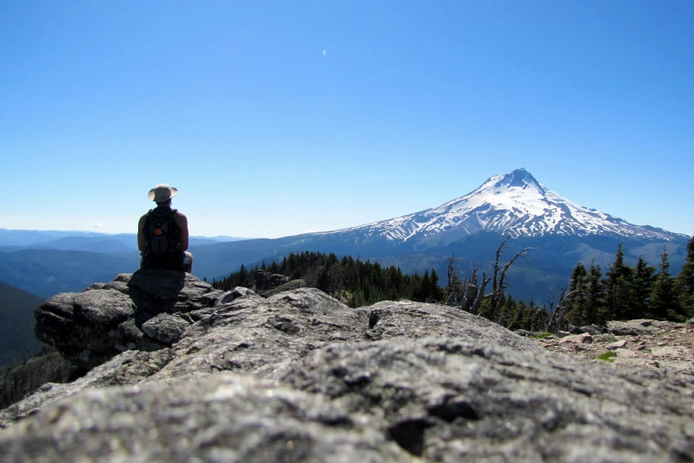 a person on top of a rock looking at a mountain