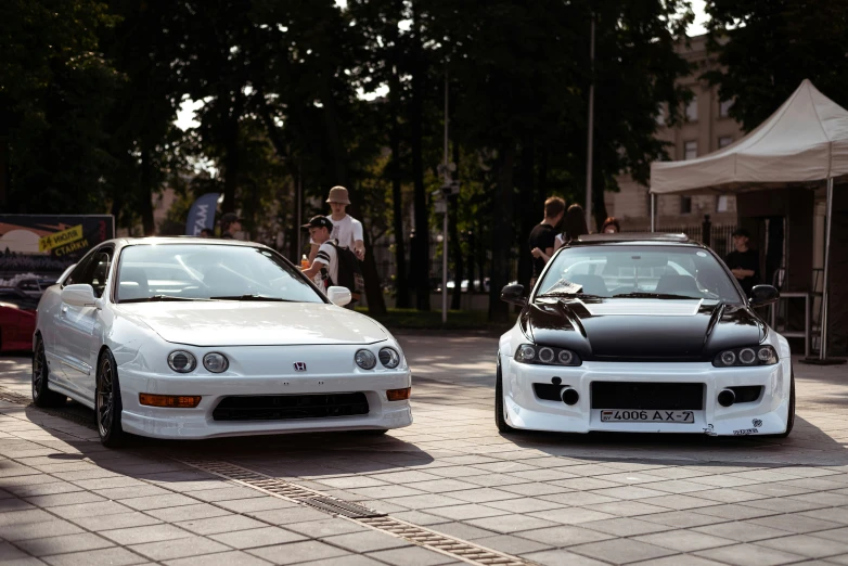 a white car parked next to another car on a street