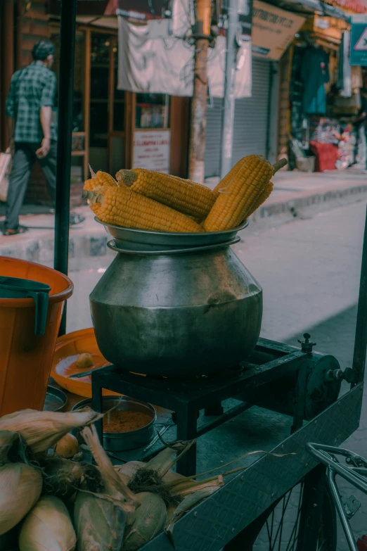 corn is on a street with people in the background