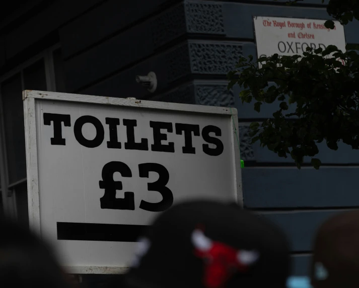 a bathroom sign hanging in front of a building