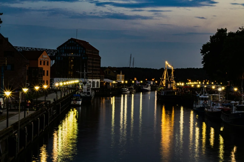 many boats are docked at the end of a river