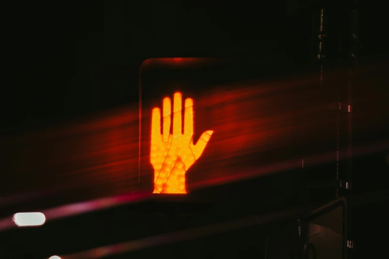 a stoplight that has the symbol of a hand in red