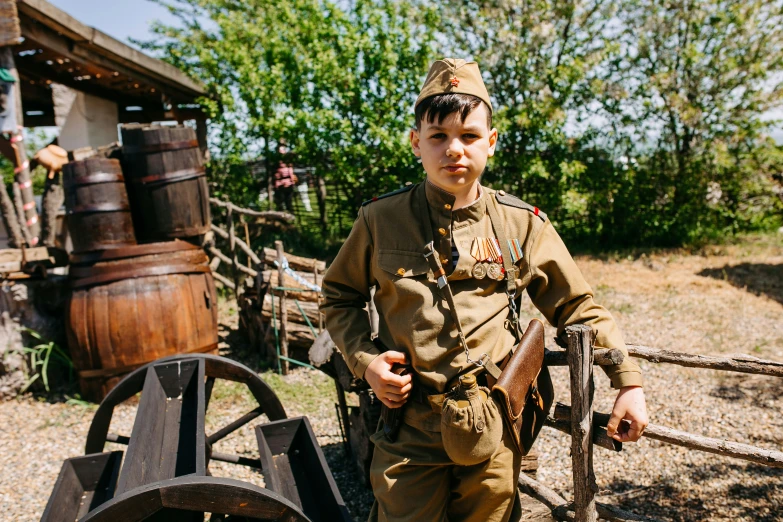 the little boy dressed in an army uniform poses for a picture