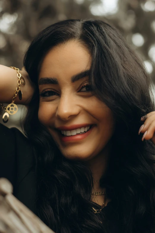 a woman smiles while leaning against a tree