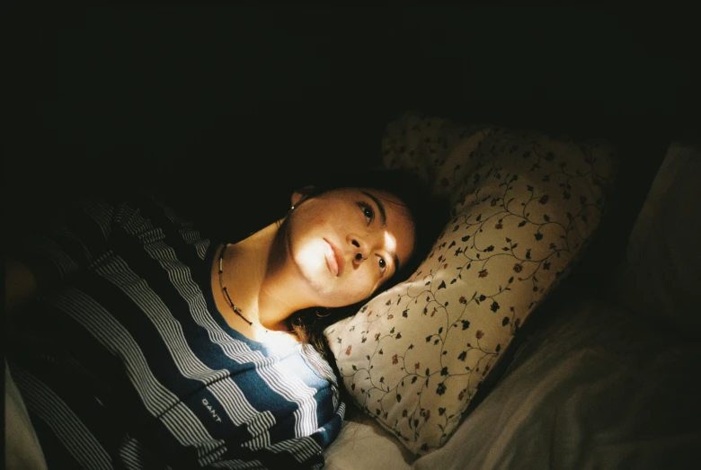 young man in bed under light from sun