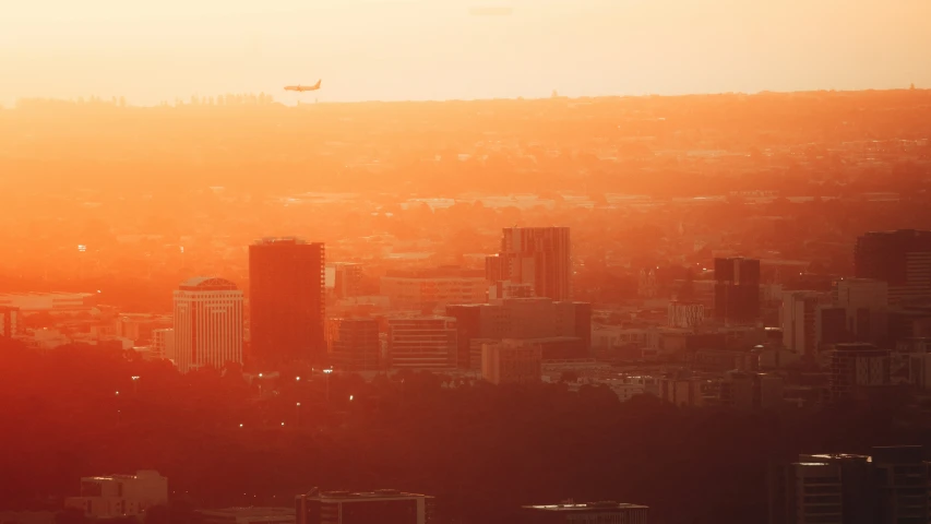 an orange sky over a city with skyscrs