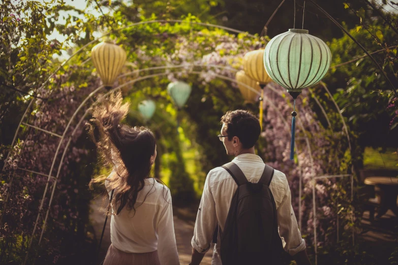 a young couple are looking into an archway at an outdoor garden