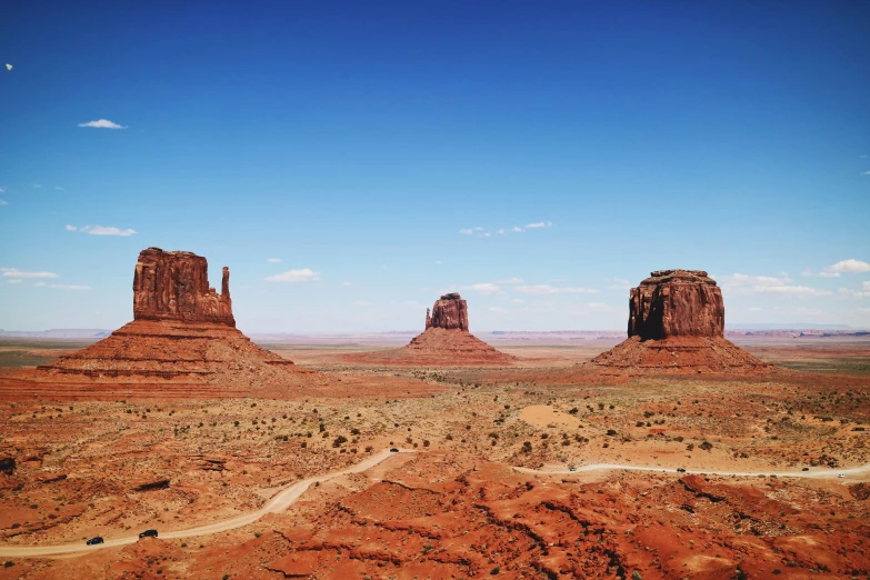 some tall rocky out buildings in the middle of a desert