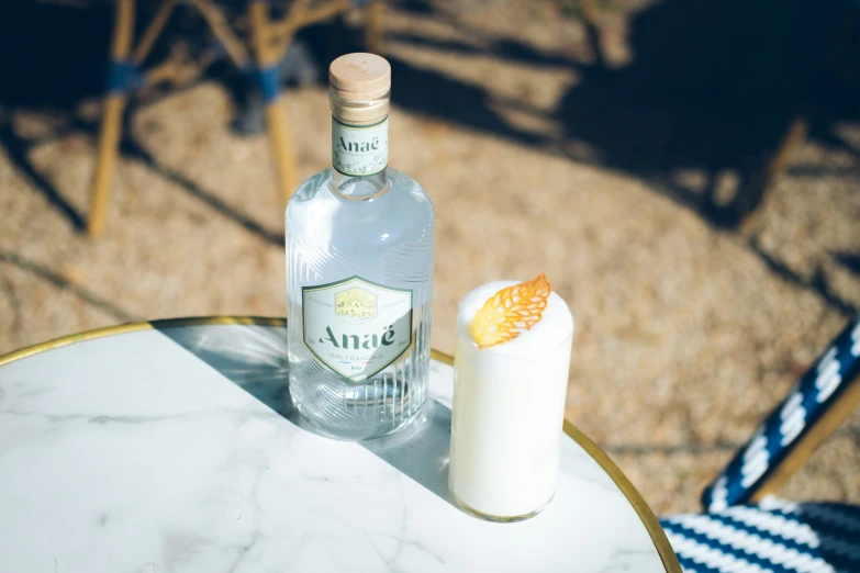 a bottle and glass on a table with a drink