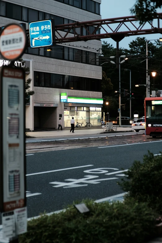 a couple of red busses and some signs on a street