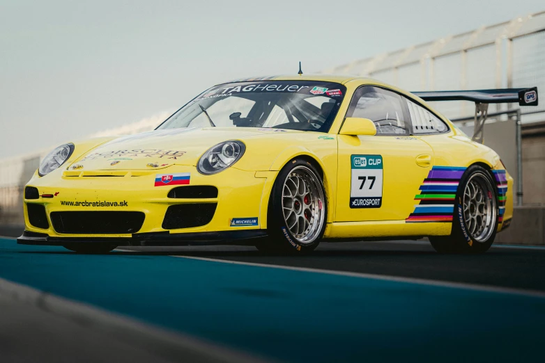 a yellow sports car with stripes on its hood