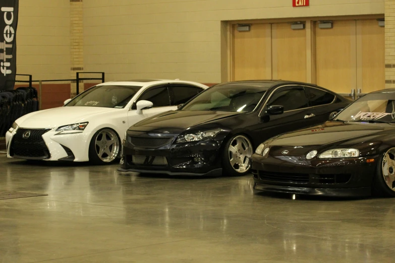 four cars parked in a garage, with the doors open