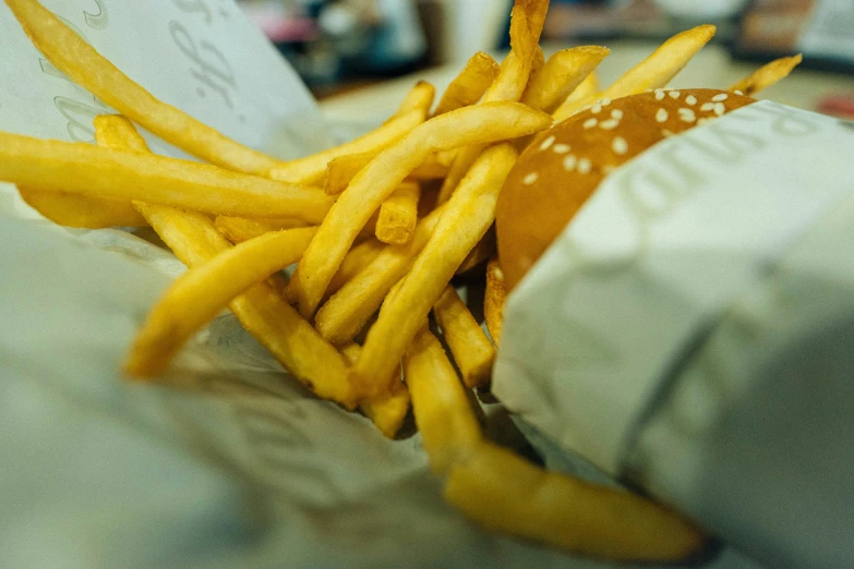 french fries are on a plate near paper