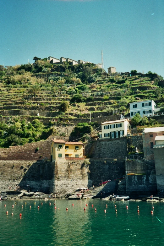 many houses in the hills are perched on the hillside by the water