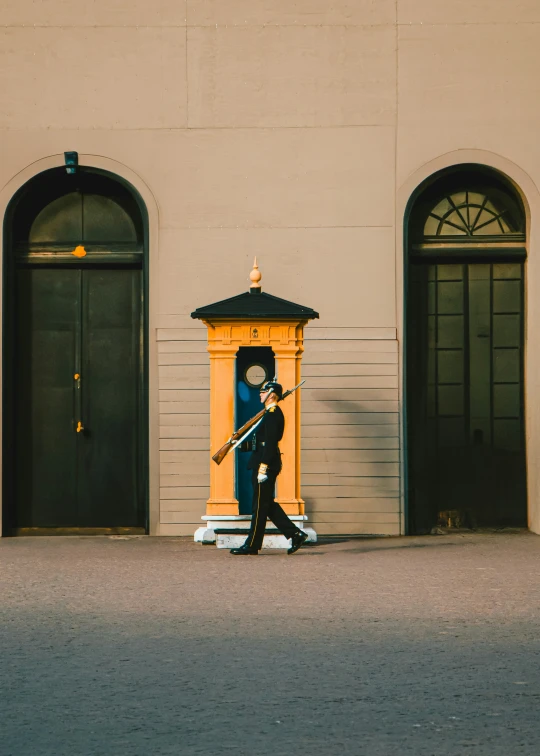 a woman carrying a yellow pole across the street