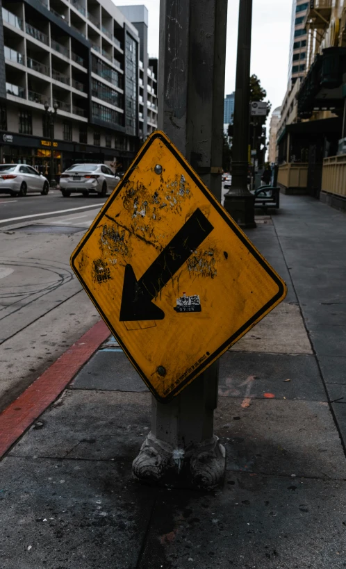 a yellow traffic sign with a arrow painted on it