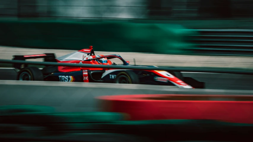 a race car racing on a track with green grass