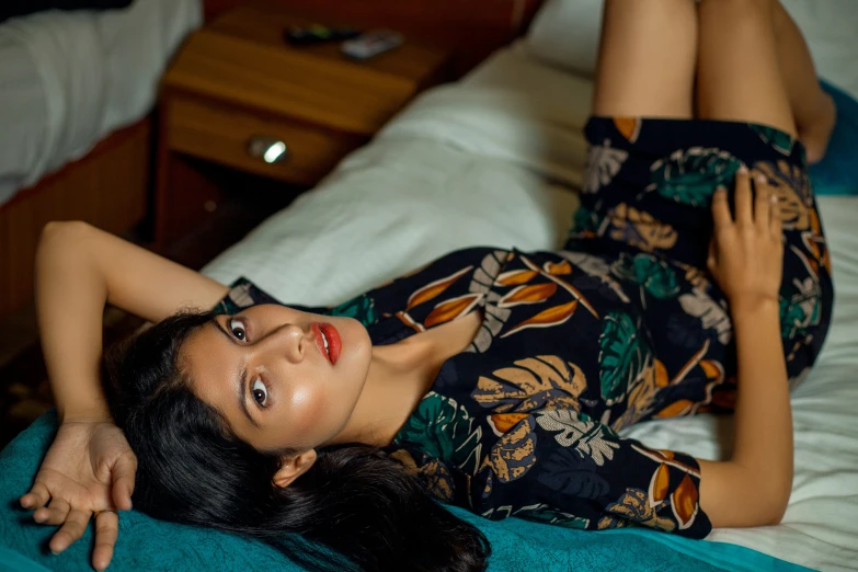 a young woman laying on top of a bed