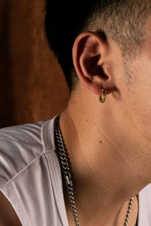 a young man with earrings and a necklace