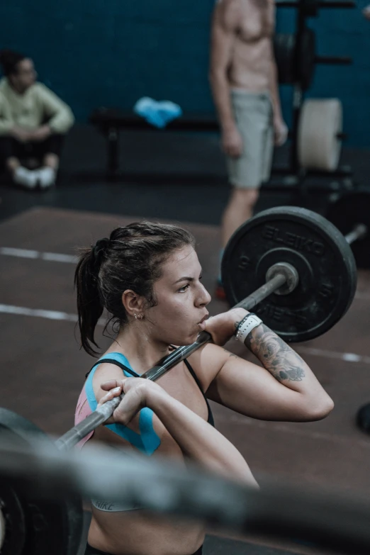 a woman with  is holding a barbell