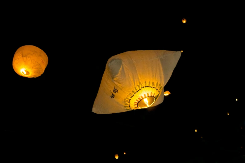 lanterns float through the air at night