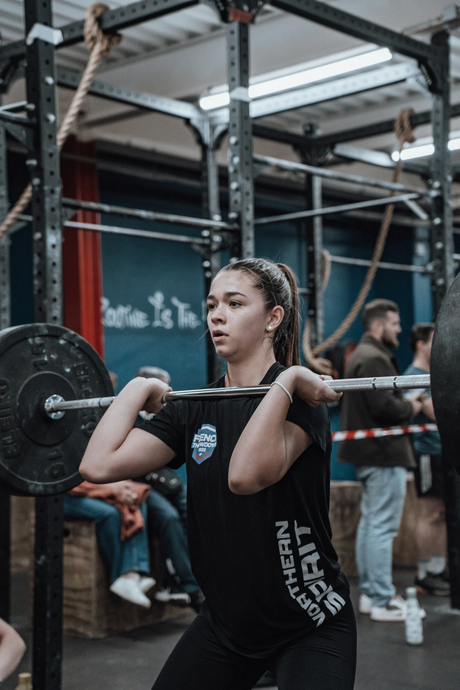 a woman standing next to a barbell in a crossfit gym