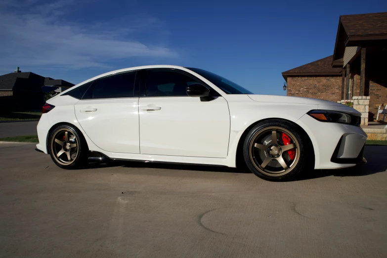 a white car with a red rim parked on the street