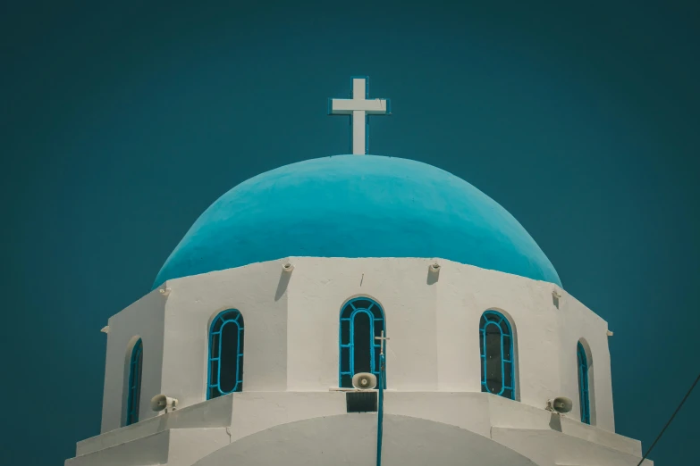 a white and blue building with a cross at the top