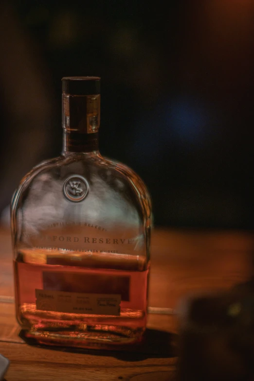 a glass bottle sitting on a table in front of a tv