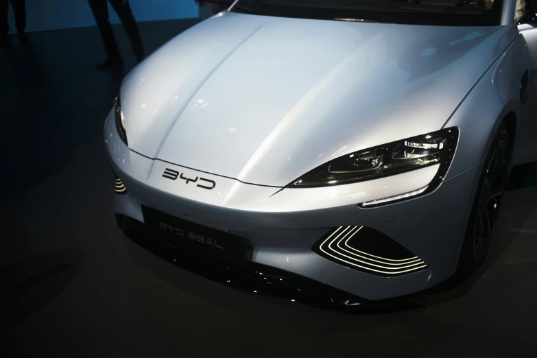 a white car sitting inside of a building next to another car