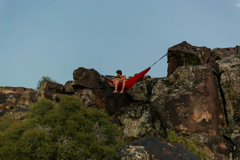 the person is using a rope to go down the mountain