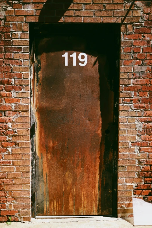 an old door with a number that reads 198 is visible next to a white trashcan
