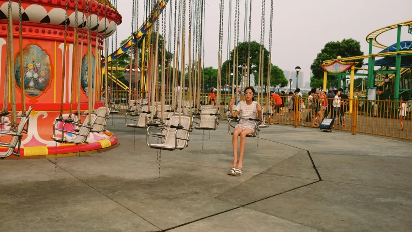 girl swinging on swing set with carousels and carousel rides