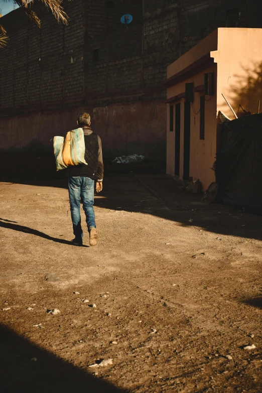 a person walks down a street carrying a backpack