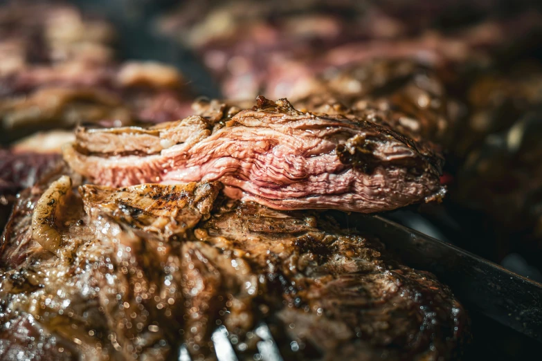 a large steak covered in brown oil and a spatula