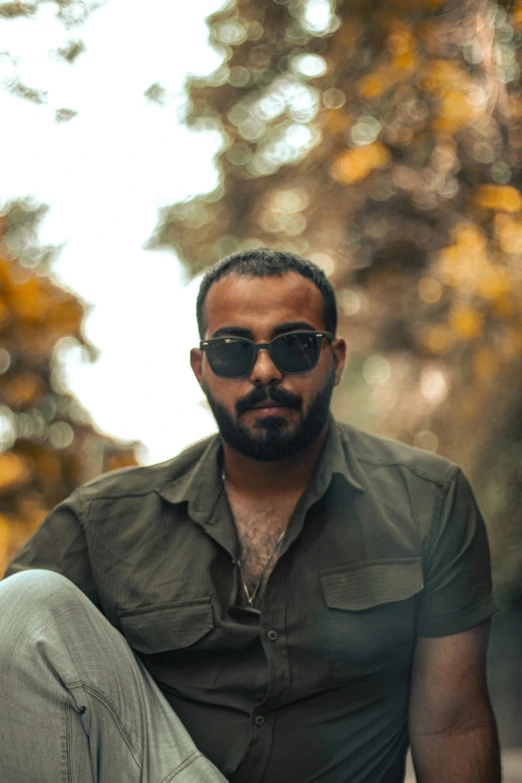 a man that is sitting down wearing sunglasses