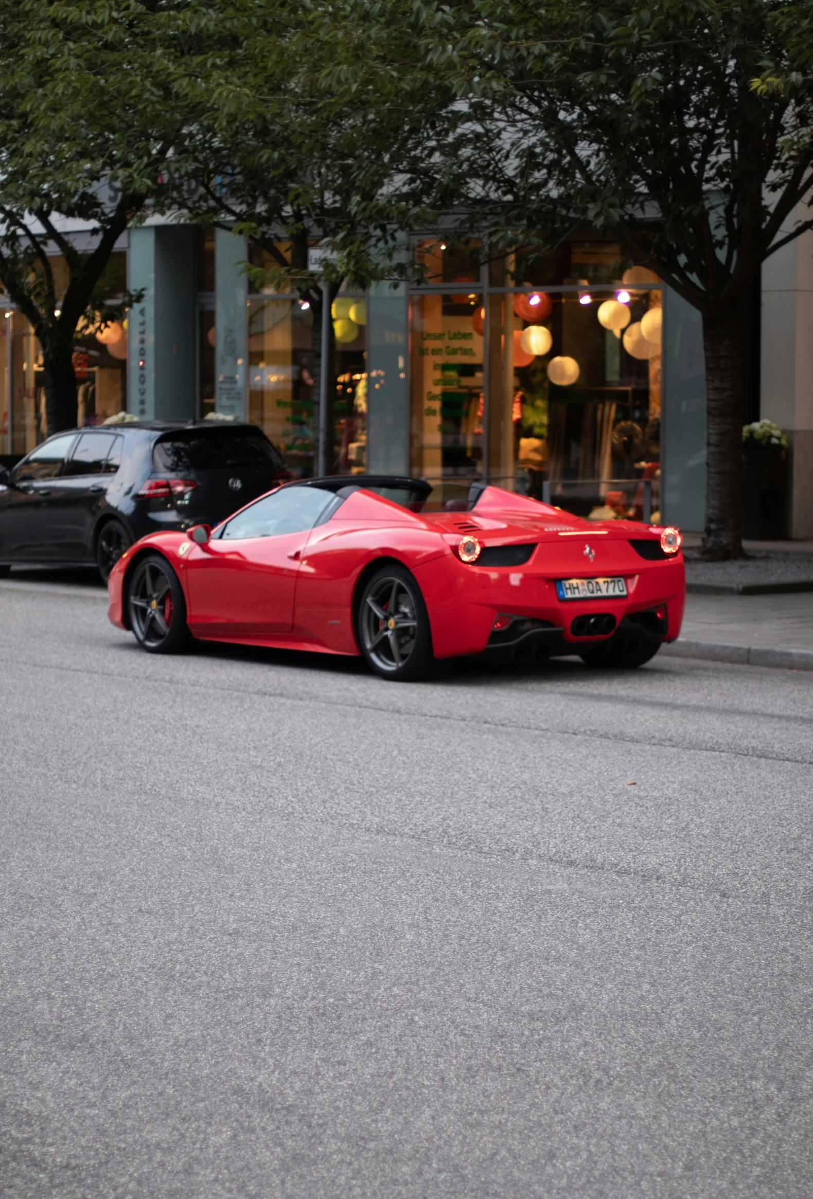 red sports car is parked next to an upscale building