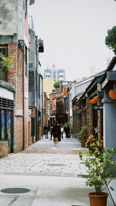 an alleyway of a city with people walking in it