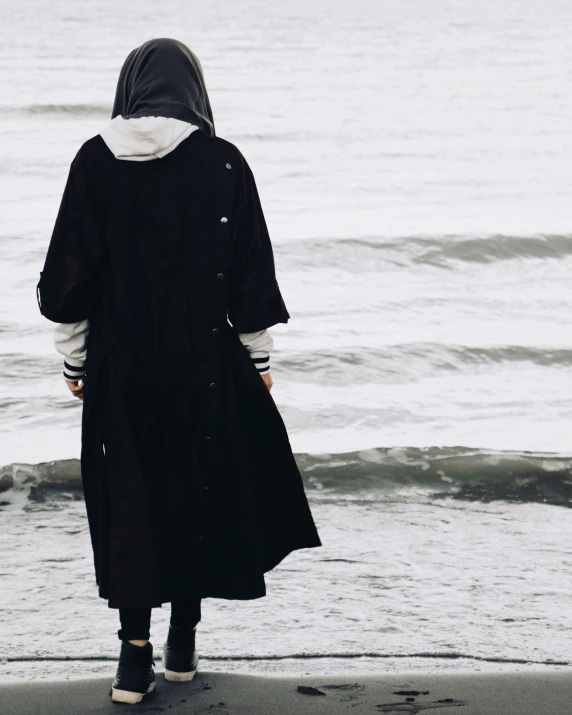 a person standing on top of a beach next to the ocean