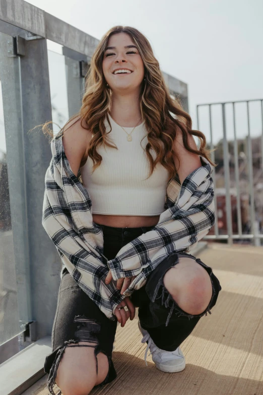 a beautiful woman sitting on a ledge wearing black and white