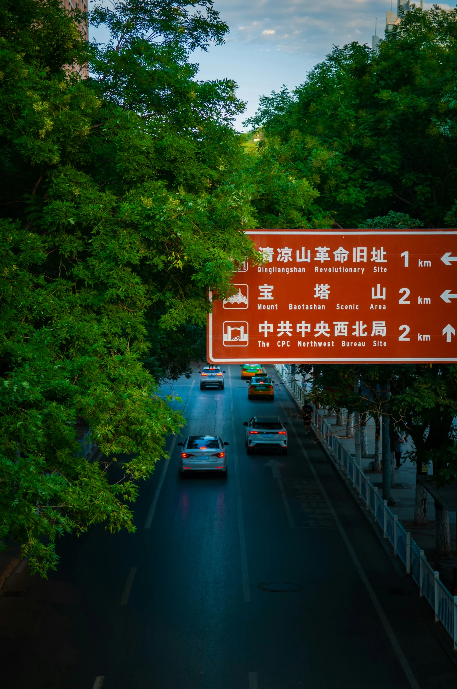 an oriental highway sign hanging over the side of a road