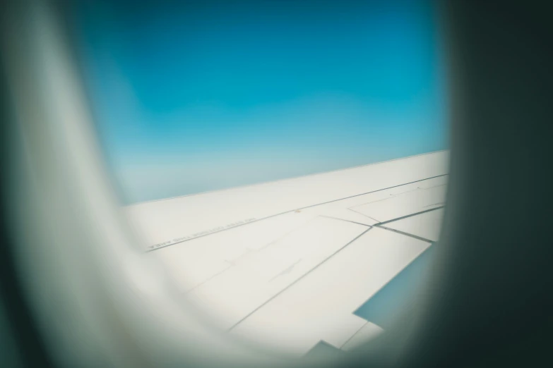 a sky view through an airplane window on an airplane