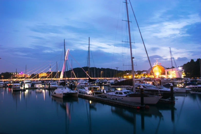 boats docked at night with lights reflecting off the water