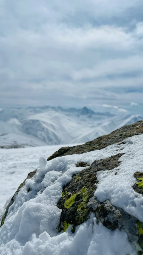 a large rock covered with snow on a mountain