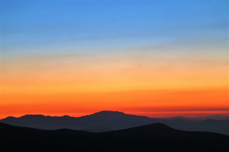 a plane is flying high over the mountains