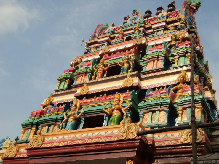 a large, colorful tower with statues at the top of it