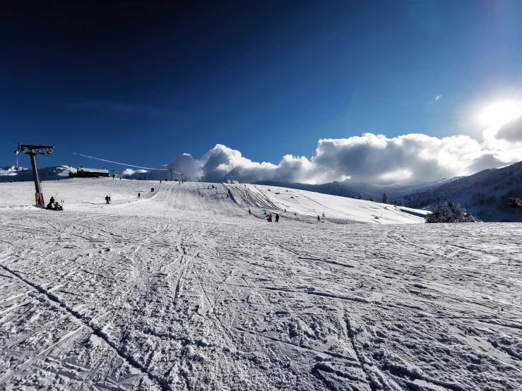 people hiking up a snowy mountain at a ski resort