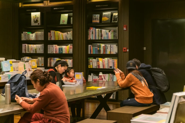 a group of people sitting around a table with laptops