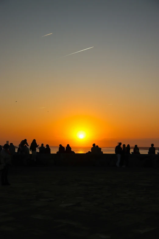 a sunset view with several people watching the sun set